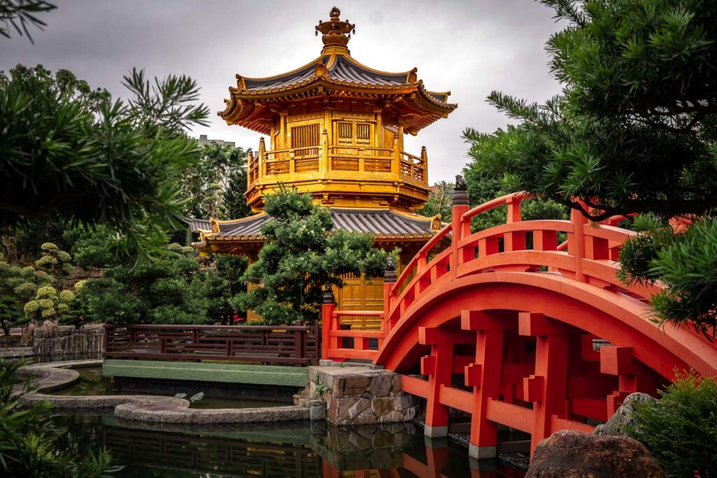 Hongkong Fotospots: Nan Lian Garten mit goldenem Tempel und roter geschwungenen Brücke im Vordergrund, umgeben von üppigem Grün.