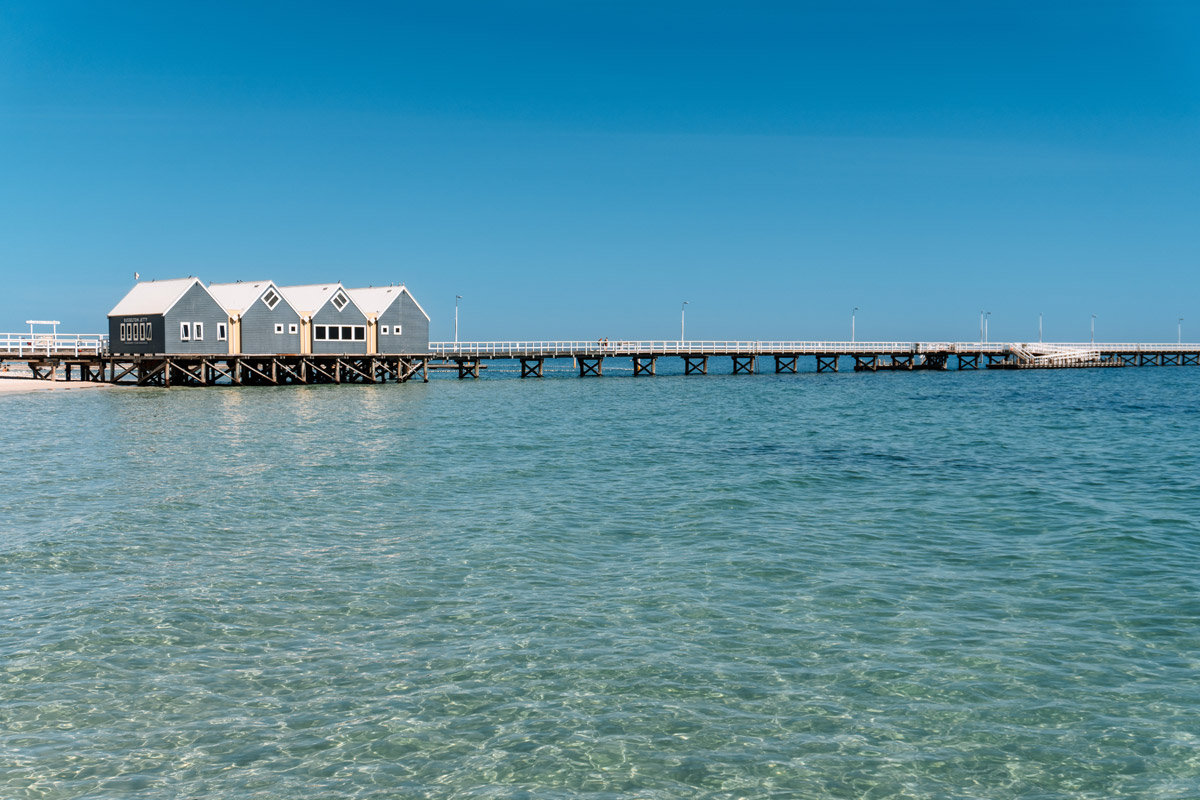 Busselton Jetty mit blau-weißen Gebäuden im türkisblauen Wasser Westaustraliens