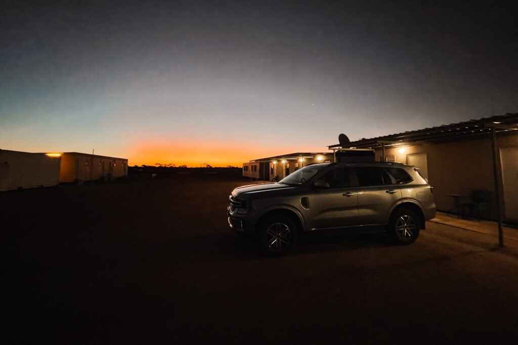Ford Everest vor Roadhouse-Unterkunft Australien in den letzten Sonnenminuten vor der Dämmerung, Auszeit Abenteuer Roadtrip
