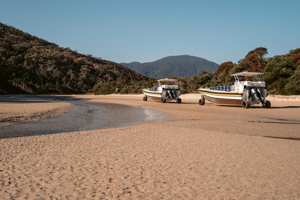Zwei Amphibienfahrzeuge für Bootstouren am Ufer des Tidal River im warmen Licht der Golden Hour am Norman Beach, Wilsons Promontory Nationalpark.