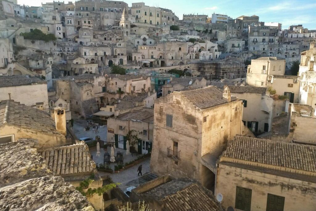 Blick vom Vorplatz der Kathedrale hinab auf die dicht gedrängten, historischen Steindächer und Gassen des Stadtteils Sasso Barisano in Matera.